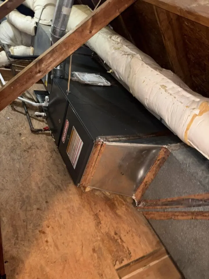 Air handler with white insulated line and sheet metal plenum in an attic